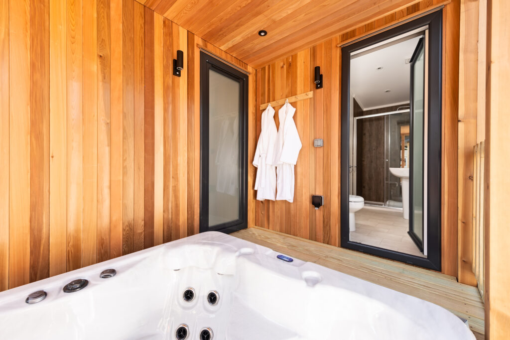 Hot tub surrounded by wood finish and accessible directly from two bedrooms